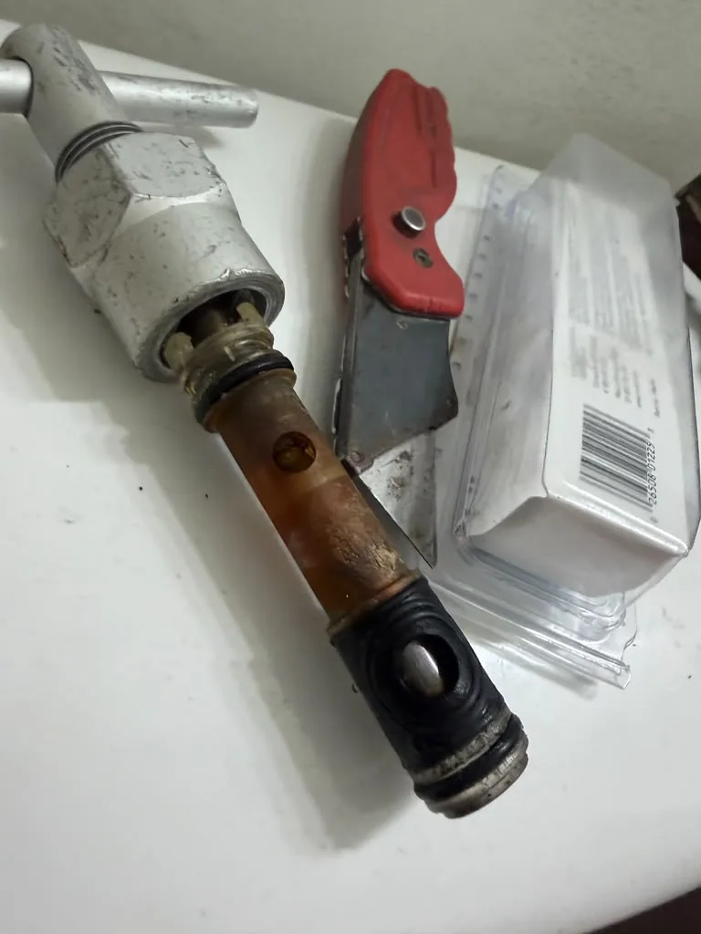 Disassembled outdoor hose bib parts laid out on a counter