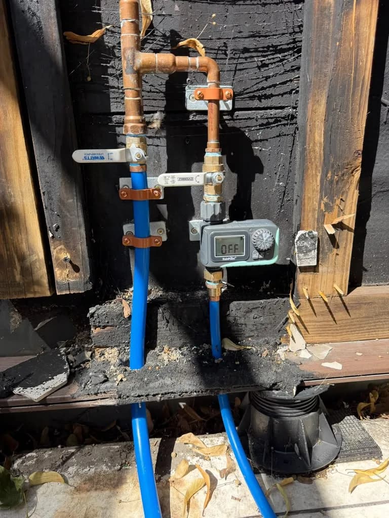 Outdoor irrigation backflow valve and shutoff assembly mounted on a wall