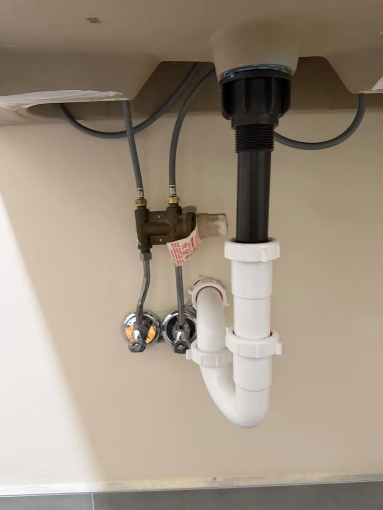 Supply lines and P-trap installed under a bathroom sink